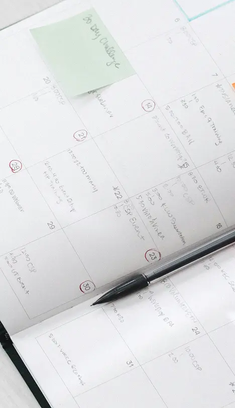 Agenda papier ouvert sur une page où on voit les rendez-vous pris pour un salon professionnel