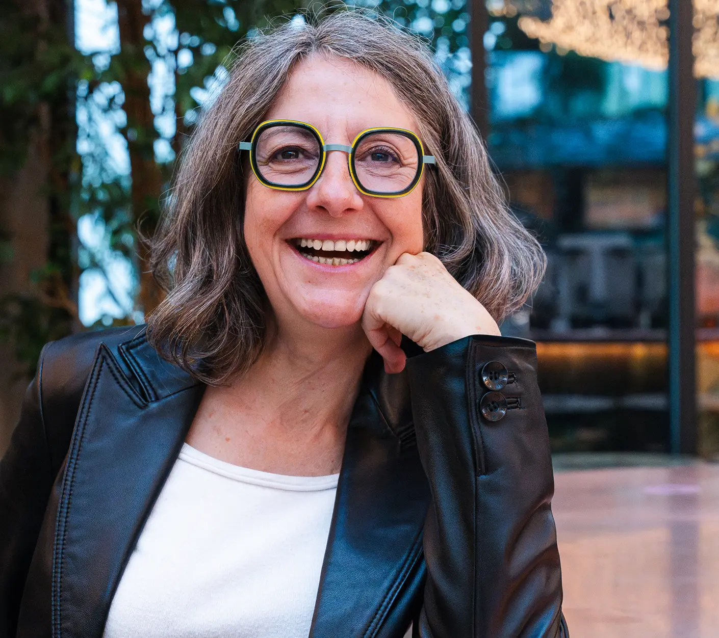 Portrait de Sandrine Bézard souriante avec la mains sous le menton